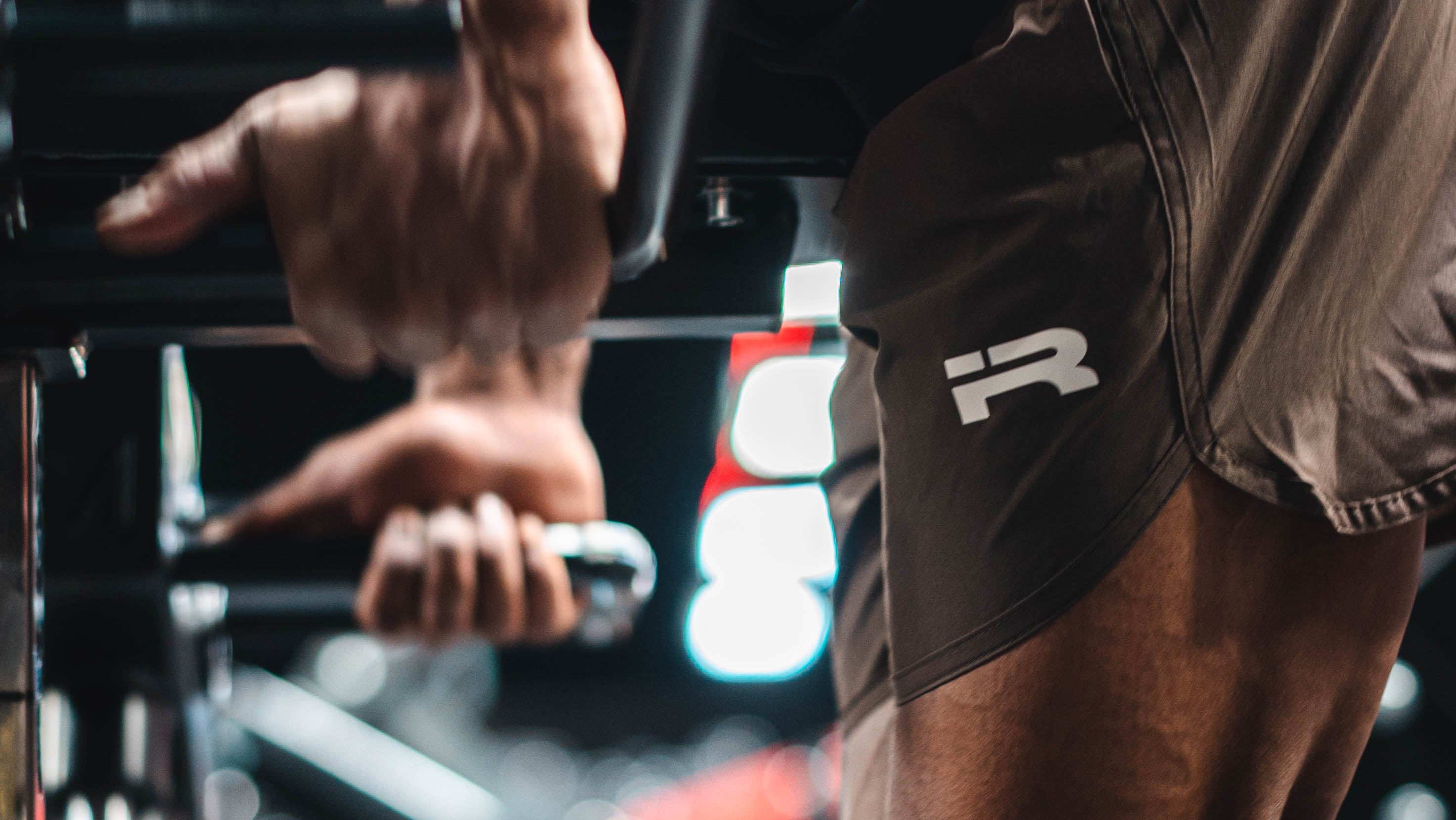 Male athlete training in brown Iron Rebel Tech Shorts at the gym.